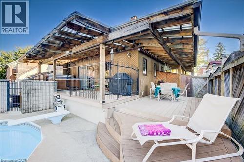 The property features a private outdoor area with a swimming pool, a diving board, and a wooden deck - 48 Dupont Street, Waterloo, ON - 