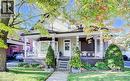 The property features a charming front porch with decorative white railings and columns, a bay window, and a neatly manicured lawn with mature trees - 48 Dupont Street, Waterloo, ON  - Outdoor With Deck Patio Veranda 