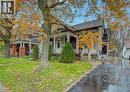 Charming property exterior featuring a covered front porch with decorative railing, a well-maintained lawn, and a paved driveway leading to a detached garage - 48 Dupont Street, Waterloo, ON  - Outdoor With Facade 