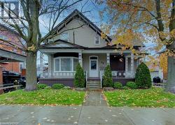 The property features a charming exterior with a covered front porch and mature trees - 