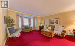 Living room with a bay window featuring blinds and patterned drapes - 