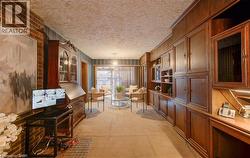 The living area features extensive built-in wooden cabinetry and paneling, a brick accent wall, and carpeting - 