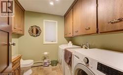 This functional space features a window with blinds, a toilet, and a vanity with a sink - 