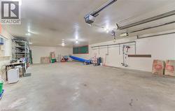 Expansive garage space featuring a concrete floor, bright overhead lighting, and track-mounted overhead garage door openers - 