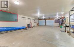 Spacious garage featuring two garage doors, concrete flooring, and overhead lighting - 