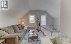 This room features two windows with blinds, a sloped ceiling, and light-colored walls - 