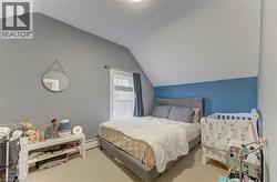 This room features a vaulted ceiling, a window with curtains, and carpeting - 