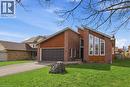 The property features a brick exterior with wood paneling accents, a two-car garage, and a well-maintained front lawn - 110 Milton Avenue, Cambridge, ON  - Outdoor 