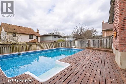 Outdoor swimming pool with a surrounding wooden deck and brick exterior - 110 Milton Avenue, Cambridge, ON - Outdoor With Above Ground Pool