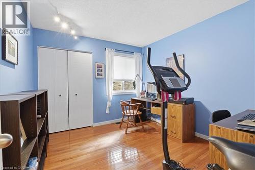 This versatile room features hardwood flooring, track lighting, and a window providing natural light - 110 Milton Avenue, Cambridge, ON - Indoor