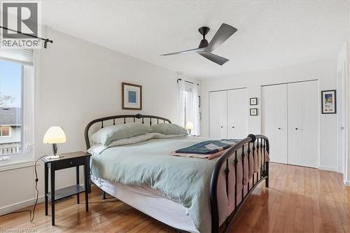 This room features hardwood flooring, white walls, and a ceiling fan - 110 Milton Avenue, Cambridge, ON - Indoor Photo Showing Bedroom