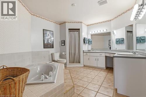 The bathroom features a built-in tub with tiled surround, a standing shower, a toilet, and a vanity with dual sinks and ample countertop space - 110 Milton Avenue, Cambridge, ON - Indoor Photo Showing Other Room