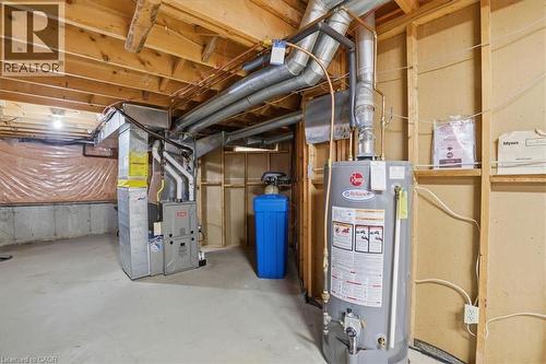 The utility area features exposed wooden beams, a water heater, a furnace, and a water softening system - 110 Milton Avenue, Cambridge, ON - Indoor Photo Showing Basement