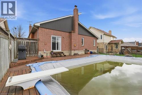 The property features a backyard with a wooden deck, a covered pool, and a diving board - 110 Milton Avenue, Cambridge, ON - Outdoor With In Ground Pool With Exterior