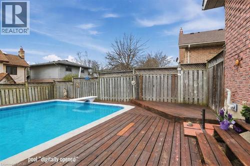 The property features a private outdoor swimming pool with a diving board, surrounded by a wooden deck - 110 Milton Avenue, Cambridge, ON - Outdoor With Above Ground Pool