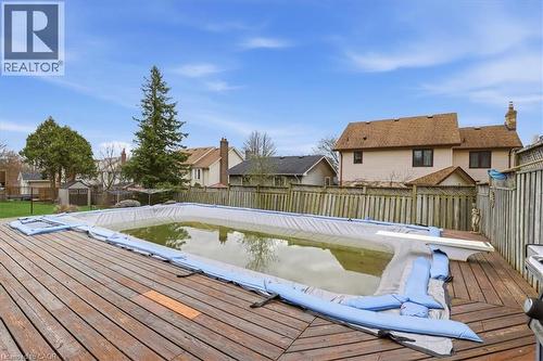 Outdoor space with a wooden deck surrounding an inground pool, enclosed by a wooden fence - 110 Milton Avenue, Cambridge, ON - Outdoor