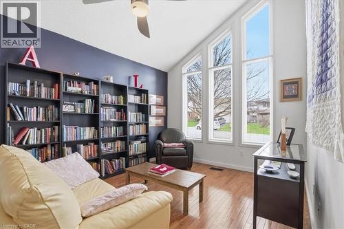 This living area features a vaulted ceiling with a fan, hardwood floors, and tall windows that provide abundant natural light - 110 Milton Avenue, Cambridge, ON - Indoor