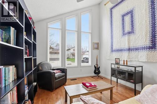 Living area featuring hardwood floors, a vaulted ceiling, and tall windows providing natural light - 110 Milton Avenue, Cambridge, ON - Indoor Photo Showing Living Room