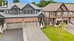 Contemporary two-story residence featuring a brick and siding facade, an attached two-car garage with panel doors, a paved driveway, and an inviting front entry with dark trim - 
