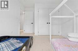 Bedroom featuring light-toned carpet flooring, white walls, and white trim - 