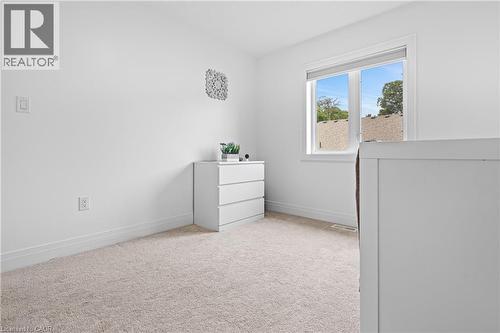 Bright interior space featuring a double-paned window, neutral wall paint, and light-toned carpeting - 1026 Wright Drive, Midland, ON - Indoor