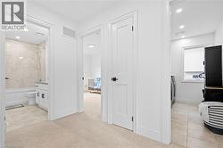 Carpeted hallway with white walls and recessed lighting - 