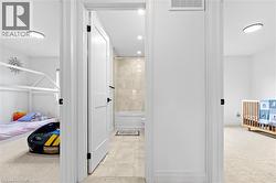 Hallway bathroom featuring a white soaking tub, tiled shower surround, and recessed lighting - 