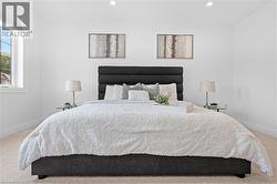 Spacious bedroom with light-toned carpet flooring and bright white walls - 
