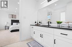 Bathroom vanity with a dark countertop and undermount sink, complemented by black fixtures and hardware - 