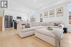 Open-concept living space featuring wood-finish flooring throughout - 