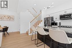 Kitchen island featuring a granite countertop, undermount sink with a matte black faucet, and seating for three - 