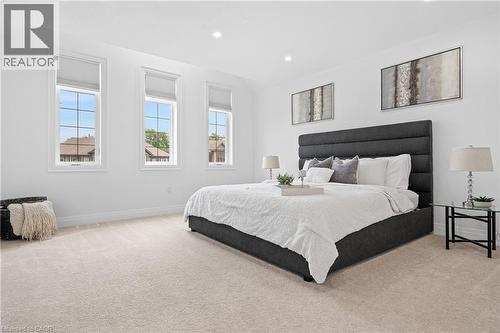 Bright room featuring three tall windows with white frames and blinds, recessed lighting, neutral tone carpet, and white baseboards - 1026 Wright Drive, Midland, ON - Indoor Photo Showing Bedroom