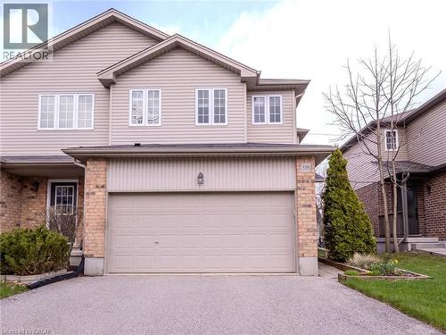 The property features a two-story exterior with light-colored siding and brick accents - 338 Maverick Street, Waterloo, ON - Outdoor With Exterior