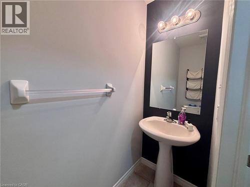 Bathroom featuring a pedestal sink, a wall-mounted mirror, and overhead vanity lighting - 338 Maverick Street, Waterloo, ON - Indoor Photo Showing Bathroom