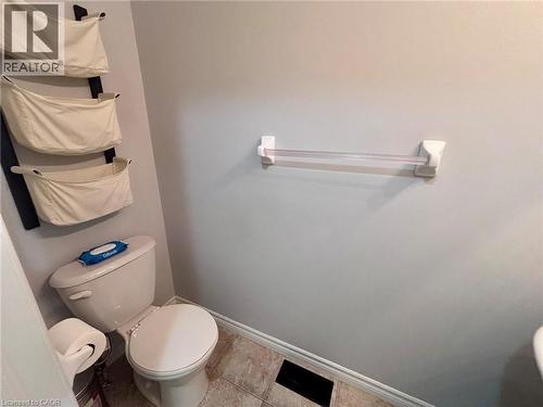The bathroom features a toilet and tiled flooring - 338 Maverick Street, Waterloo, ON - Indoor Photo Showing Bathroom
