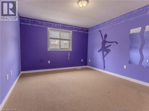 The property features a room with light brown carpeting, a window with blinds, and a ceiling-mounted light fixture - 338 Maverick Street, Waterloo, ON - Indoor Photo Showing Other Room