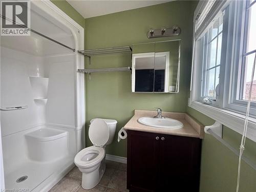 The bathroom features a white shower stall, a toilet, and a vanity with an oval sink and a dark wood cabinet - 338 Maverick Street, Waterloo, ON - Indoor Photo Showing Bathroom