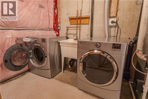 Laundry area featuring a front-loading washing machine, a dryer, and a utility sink - 338 Maverick Street, Waterloo, ON - Indoor Photo Showing Laundry Room