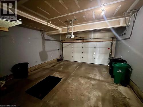 The property features an attached garage with a concrete floor and an overhead garage door - 338 Maverick Street, Waterloo, ON - Indoor Photo Showing Garage