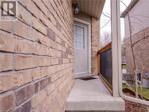 The property features an exterior brick facade, a concrete entryway, and a covered porch with a railing - 338 Maverick Street, Waterloo, ON - Outdoor