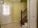 Entryway featuring tiled flooring, a white paneled door with window, and a carpeted staircase with a dark wood banister - 338 Maverick Street, Waterloo, ON  - Indoor Photo Showing Other Room 