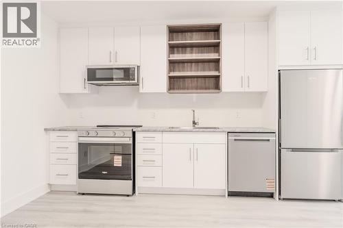 The kitchen features white cabinetry, stainless steel appliances, and light-colored countertops - 144 Everett Common, St. Catharines, ON - Indoor Photo Showing Kitchen