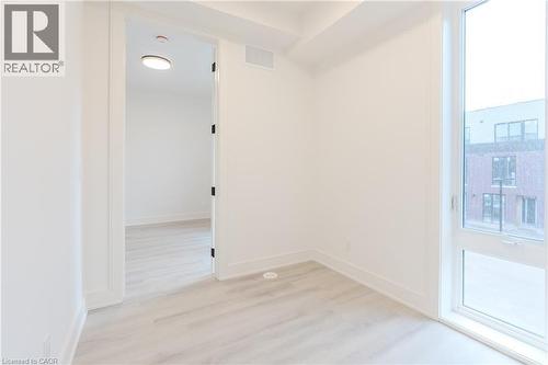 This space features light-toned flooring, white walls, and a window providing natural light - 144 Everett Common, St. Catharines, ON - Indoor Photo Showing Other Room