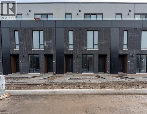 The property features a contemporary facade with dark brick and large windows - 144 Everett Common, St. Catharines, ON - Outdoor