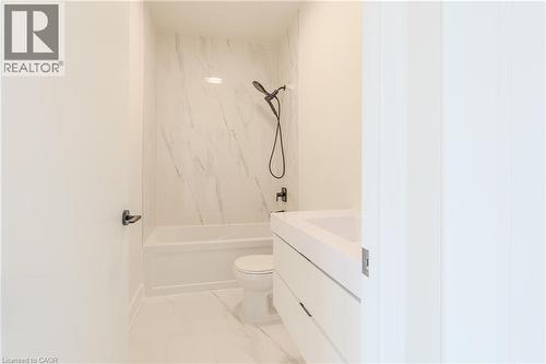 Bathroom featuring a white bathtub, toilet, and vanity with a rectangular sink - 144 Everett Common, St. Catharines, ON - Indoor Photo Showing Bathroom