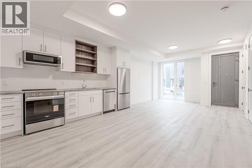 Open concept living area with light-toned flooring and white walls - 144 Everett Common, St. Catharines, ON - Indoor Photo Showing Kitchen
