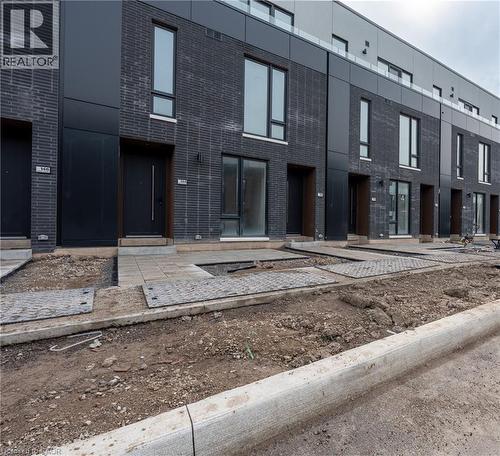 The property features a dark brick exterior with black paneling and tall windows - 144 Everett Common, St. Catharines, ON - Outdoor