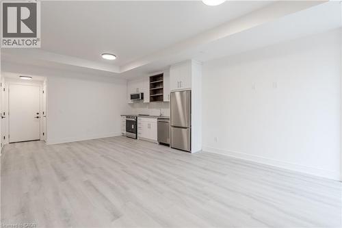 The property features a bright open room with light-toned flooring, white walls, and recessed lighting - 144 Everett Common, St. Catharines, ON - Indoor Photo Showing Kitchen