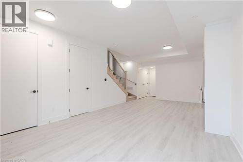 Spacious interior featuring light-toned flooring and white walls, complemented by modern flush-mount lighting fixtures - 144 Everett Common, St. Catharines, ON - Indoor Photo Showing Other Room