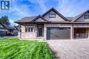 Modern façade featuring stone veneer and horizontal siding accents, a dark entry door, and a single-car garage with transom windows - 48 Main Street E, Innerkip, ON  - Outdoor With Facade 